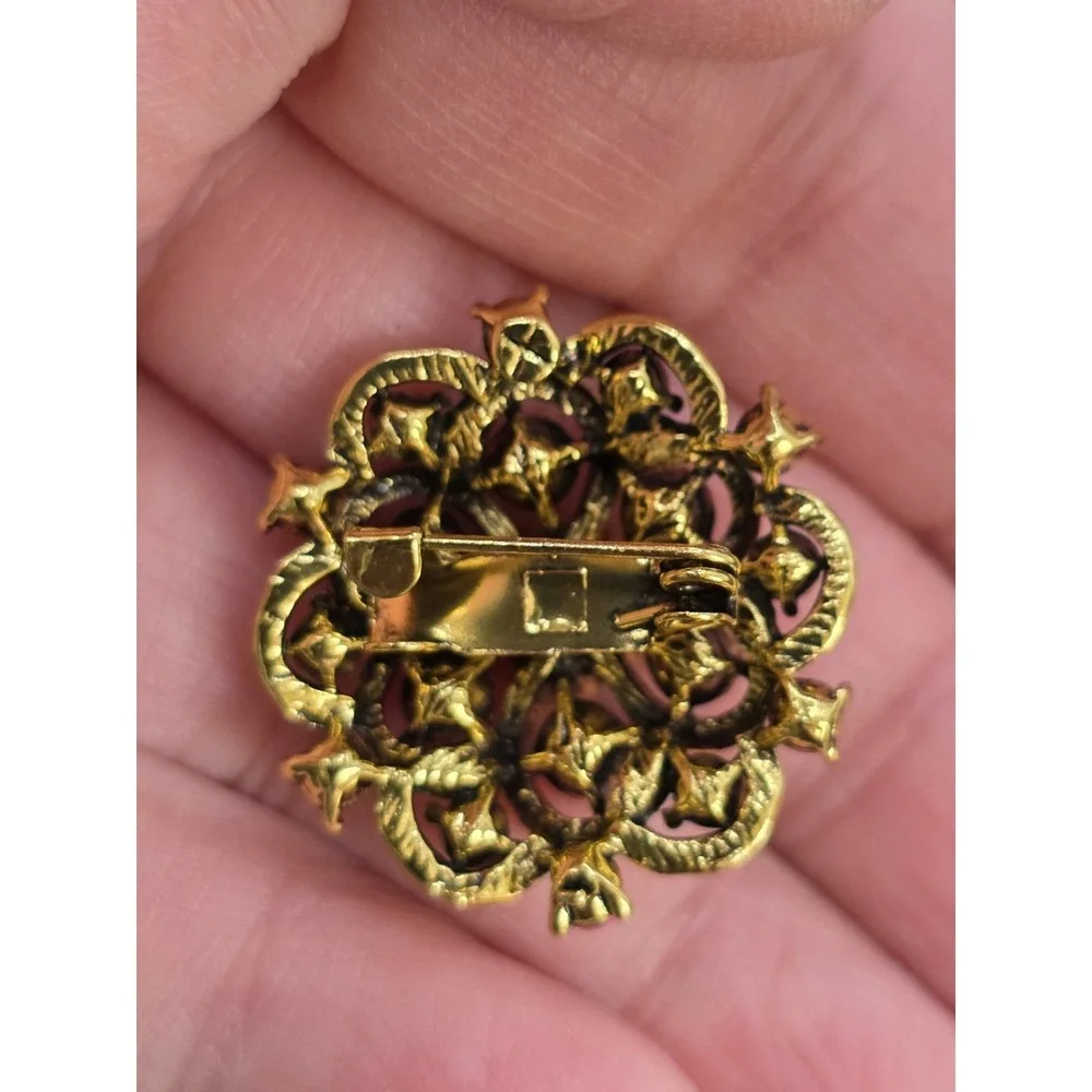 gold-toned floral brooch featuring pink and clear rhinestones